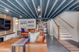 Room with leather couches and white stairs
