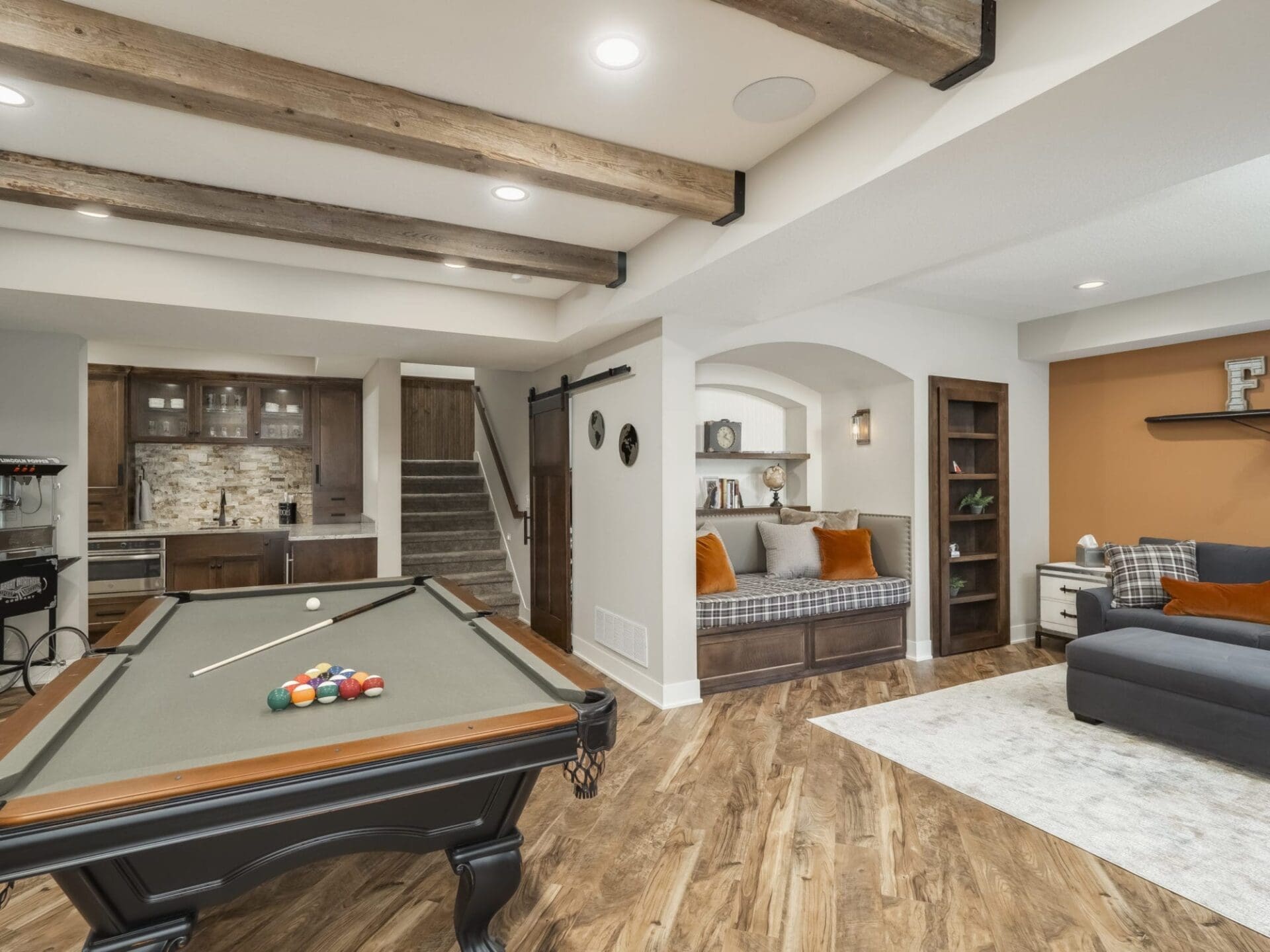 open basement remodel | game room | arcade | reading nook | wet bar | warm woods aand grey walls | fbc remodel