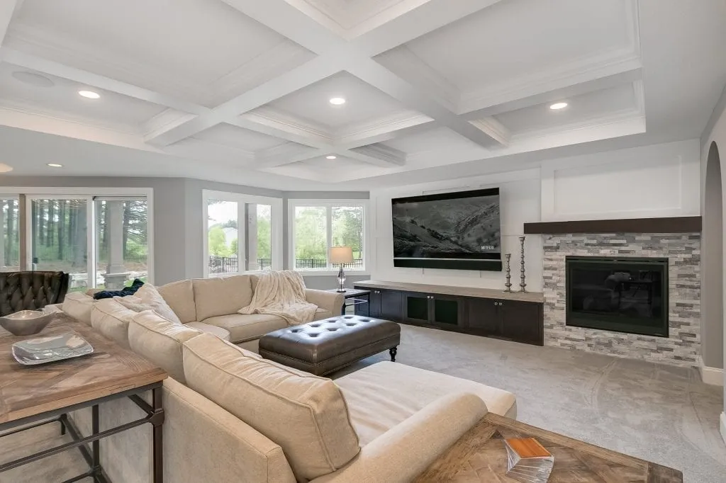 basement remodel with home theater and stone fireplace wall
