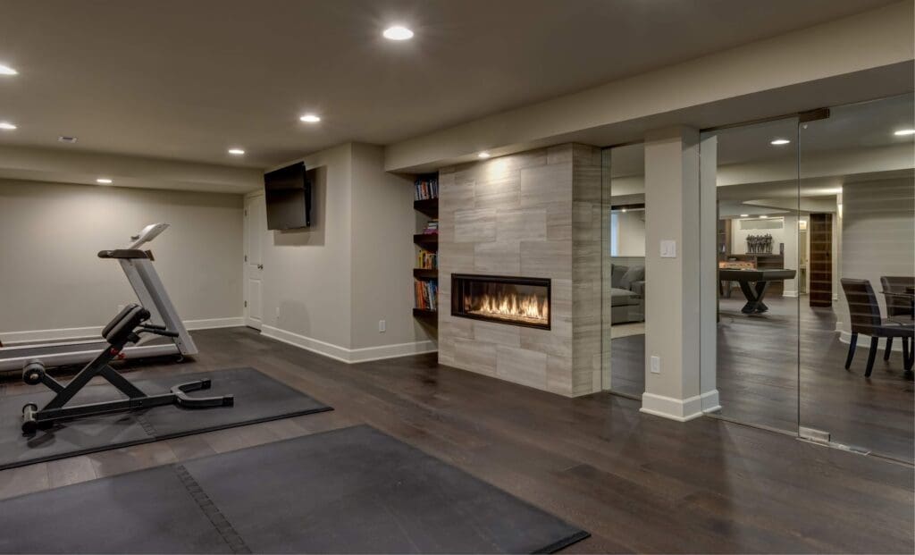 Basement gym with treadmill, rubber flooring, and glass partition
