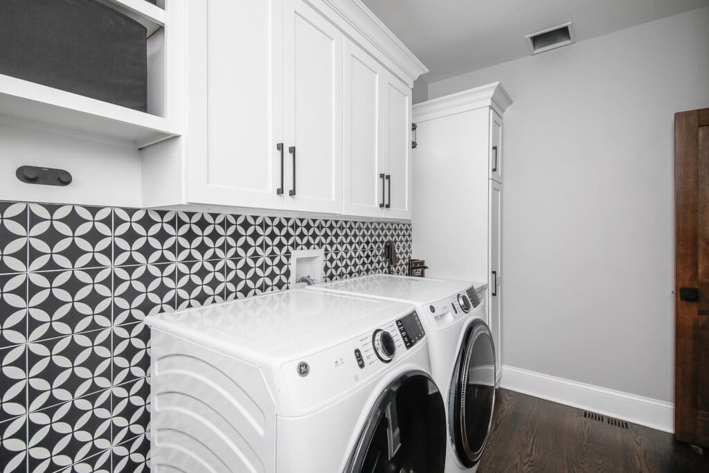 Black and white laundry room with patterned tile backsplash