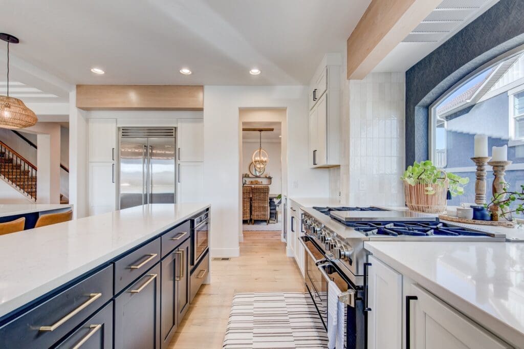 Luxury kitchen with navy and white cabinetry, double ovens, and large island