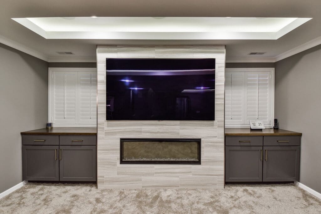 Basement entertainment center with wall-mounted TV and fireplace