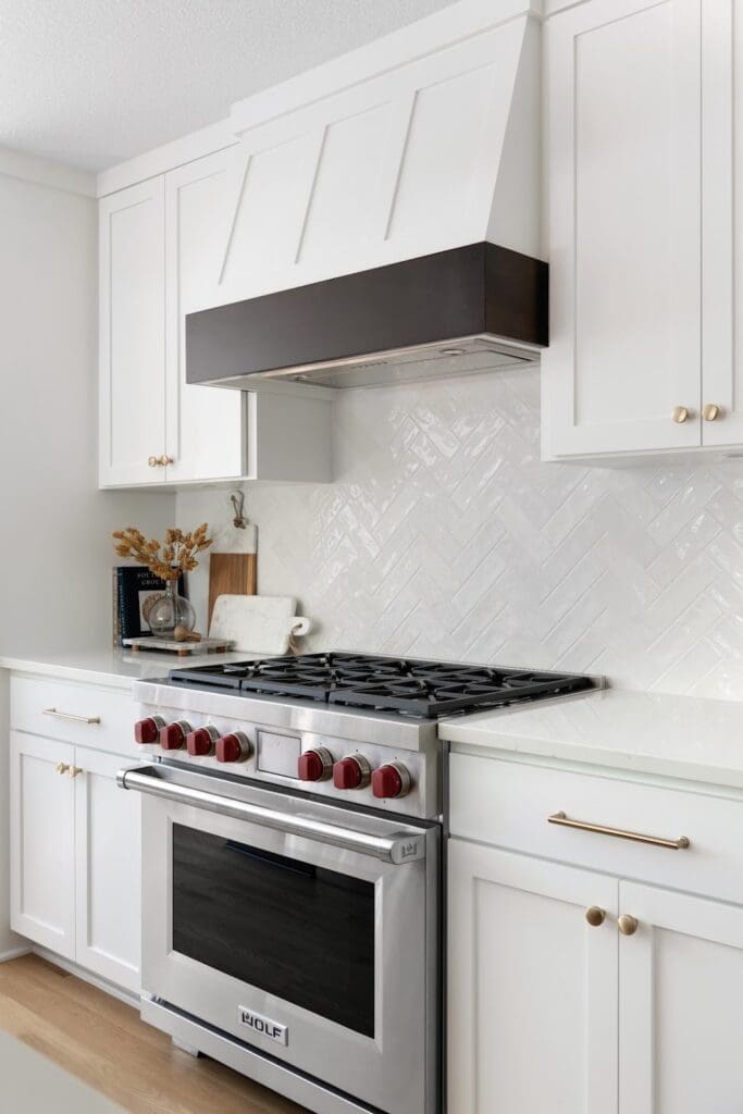 Bright white kitchen with luxury Wolf range and herringbone backsplash