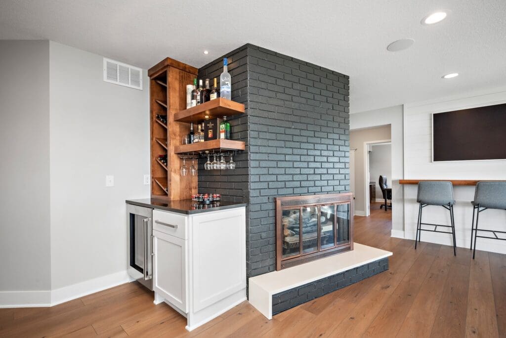  Home wet bar with brick accent wall, open wood shelves, and wine storage