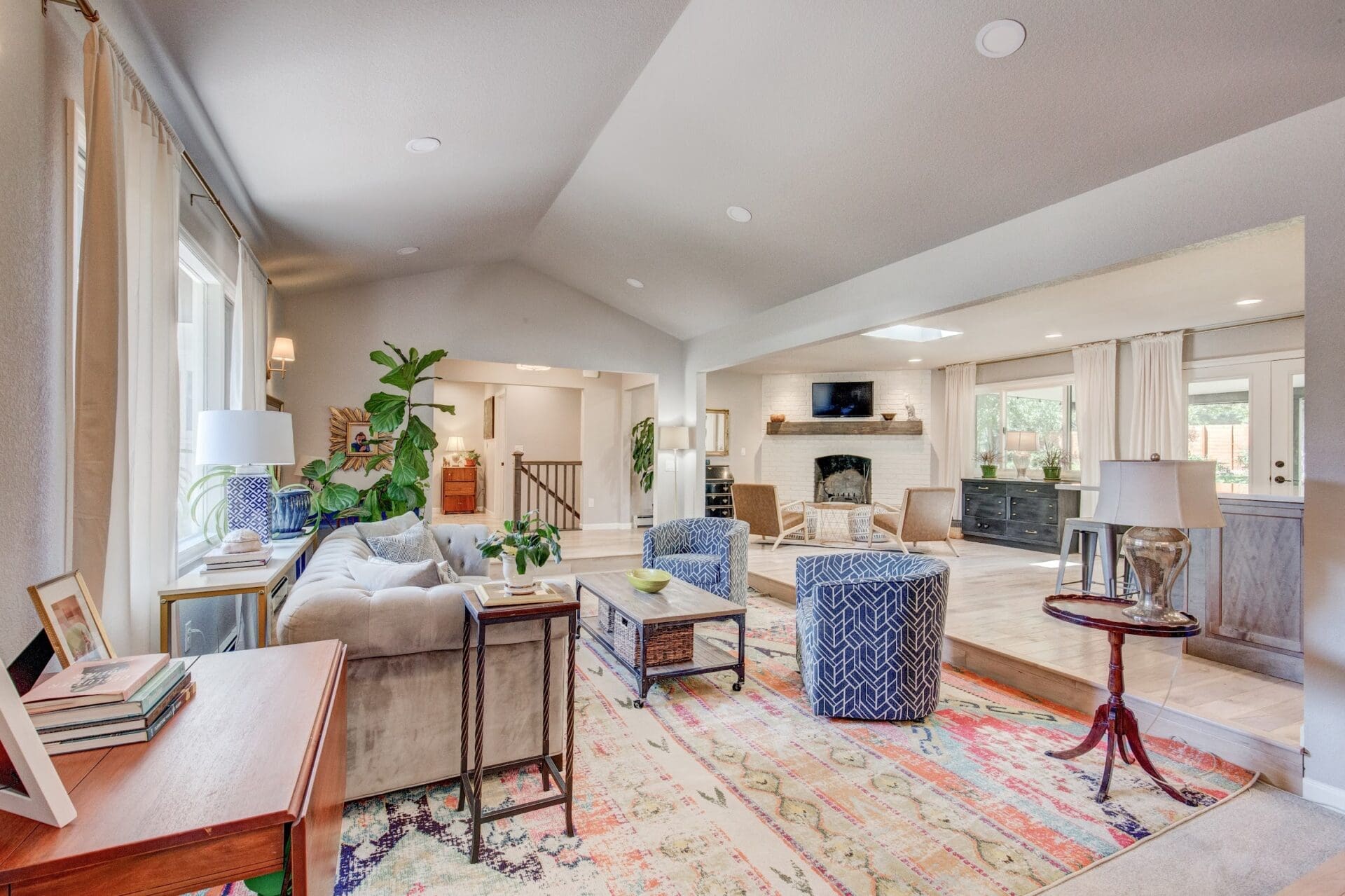 Eclectic living room with colorful rug, tufted couch, and bright natural light