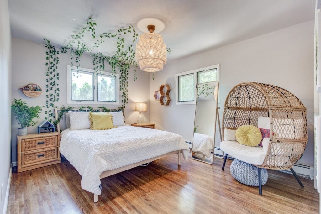 Boho-inspired bedroom with rattan chair, hanging greenery, and soft textures