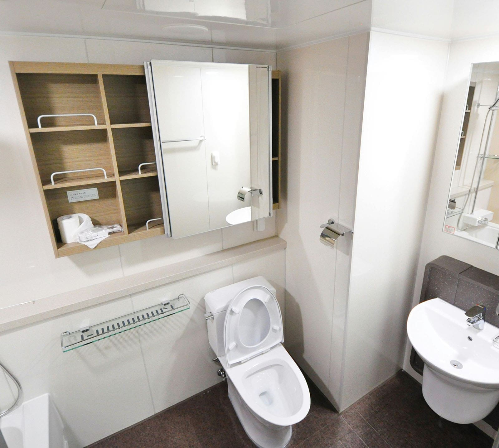 Tiny bathroom ideas - A bathroom mirror that slides over wall-mounted cabinets
